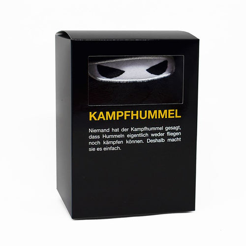 Kampfhummel Plüschtier in der schwarzen Verpackungsbox mit Sichtfenster.